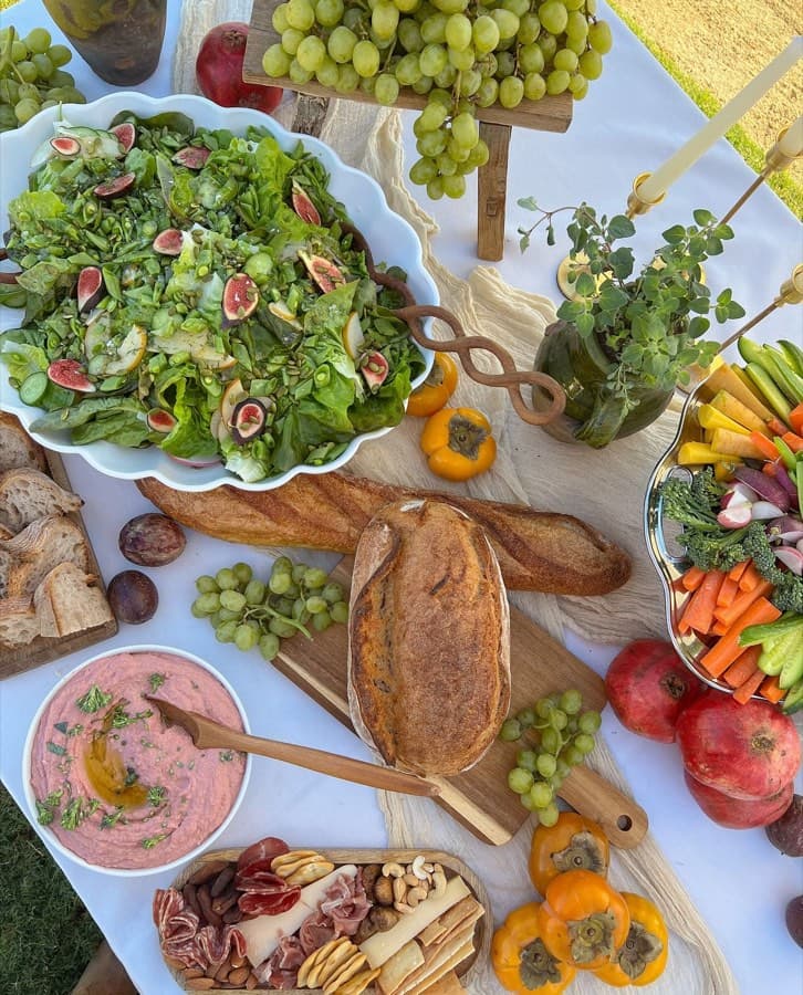 An overhead grazing table of seasonal produce, bread, and spreads